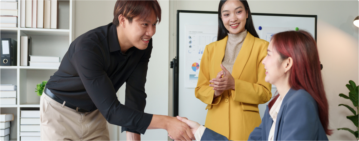 Business professionals shaking hands during a meeting, symbolizing collaboration and expertise in tax advisory services.